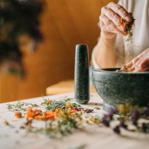 close up of woman grinding dry flowers in a mortar